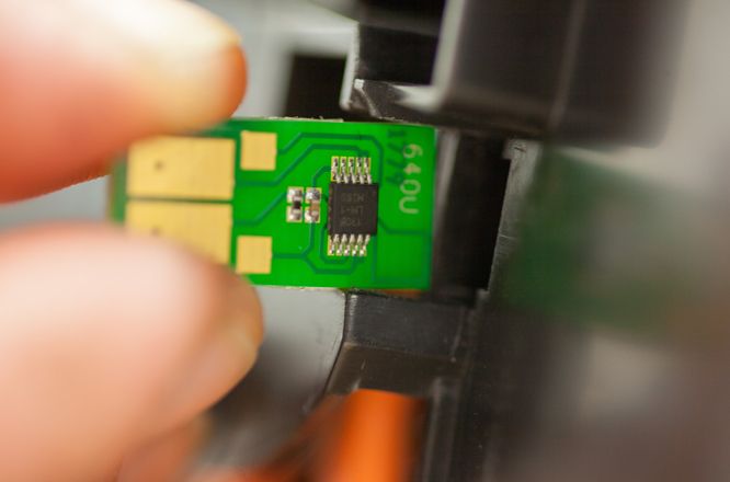 Ein neuer Chip wird an einer Tonerkartusche eingesetzt