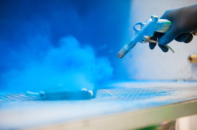 Eine zerlegte Kartusche wird mit Druckluft von altem Tonerpulver gereinigt